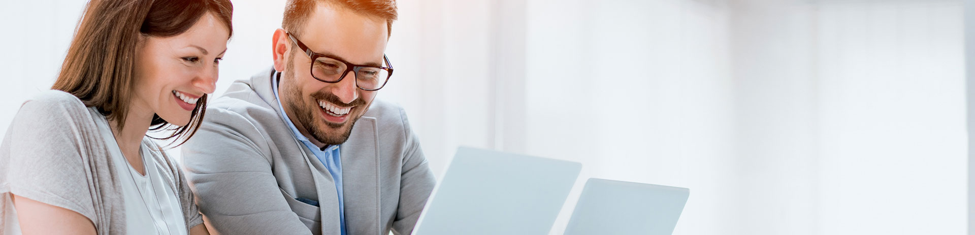 Geschäftsleute sitzen an Besprechungstisch vor Computer