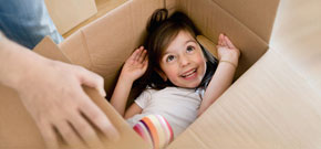 Kind in Umzugskiste